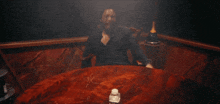 a man sitting at a table with a bottle of champagne