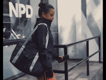 a woman walking in front of a building that says npd on it