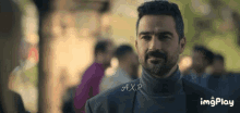 a man with a beard wearing a turtleneck sweater and a suit .