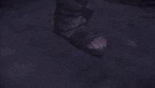 a blurred image of a man standing in the dark with his hands on his chest .