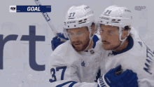 two hockey players are celebrating a goal with the sn logo in the background