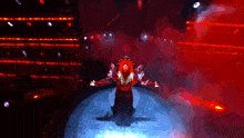 a person in a red costume is standing on a stage