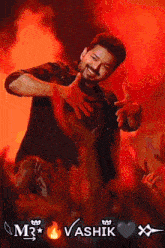a man in a black shirt is giving a thumbs up in front of a crowd and the name vashik is on the bottom