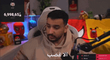 a man is sitting in front of a microphone with the number 6,998,65 on the screen
