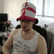 a man wearing a hat and a tank top that says stuart on it