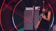 a woman is singing into a microphone while holding a guitar and wearing a shirt with the number 17 on it