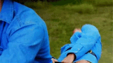 a man in a blue shirt is holding a woman 's leg