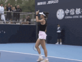 a woman is playing tennis in front of a sign that says china com