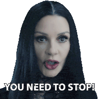 a woman with long black hair has a sticker on her face that says " you need to stop "