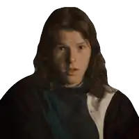 a young man with long hair is wearing a black jacket