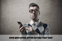 a man wearing glasses is holding a cell phone in his hand .