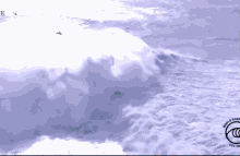 a surfer is riding a wave with the letter e in the background