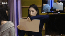 a girl is holding a piece of paper with idol radio written on it