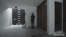 a woman stands in front of a door with the words made in animatica on the bottom