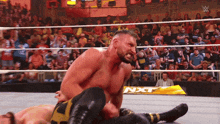 a man in a wrestling ring with a sign that says nxt in the background