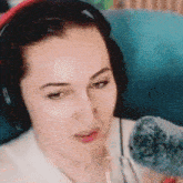 a woman wearing headphones is holding a microphone in her hand .