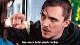 a man in a black shirt says you are a total punk rocker in front of a woman