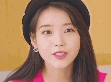 a close up of a woman wearing a black beret and earrings .