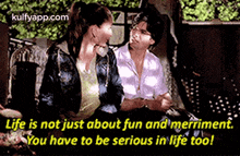 a couple of women are sitting next to each other on a couch and talking .
