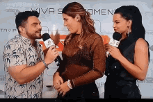 a man is talking into a microphone while a woman looks on .