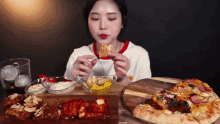 a woman is sitting at a table eating a pizza