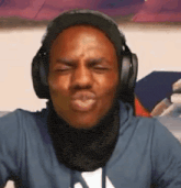 a man wearing headphones and a scarf making a funny face