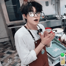 a man wearing glasses and an apron in a kitchen with chinese writing on the floor