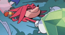 a cartoon of knuckles the echidna laying on the ground next to a green emerald .