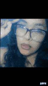 a close up of a woman wearing glasses with the word xefx on the bottom right