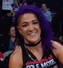 a woman with purple hair is smiling and wearing a shirt that says dole mole