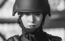 a black and white photo of a woman wearing a helmet and a hood .