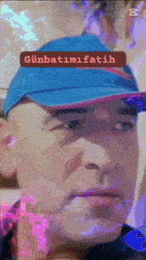a man wearing a blue hat has a sticker on his face that says günbatimi fatih