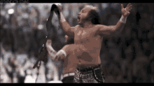 two wrestlers are holding their belts up in the air