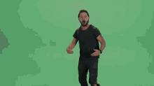 a man is dancing on a green screen in front of a green background .
