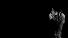 a black and white photo of a person sitting in the dark .