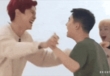 a group of young men are holding hands and laughing while standing next to each other .