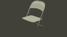 a white folding chair is against a dark background
