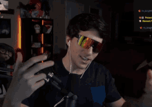 a man wearing sunglasses is talking into a microphone with a screen behind him that says its_knight