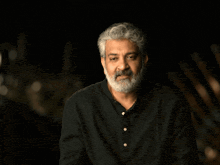 a man with a beard stands in front of a wow graphic