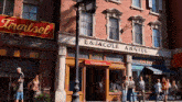 a group of people are walking down a street in front of a building that says laura cole asstel