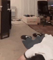a person is laying on the floor in a living room with their feet up .
