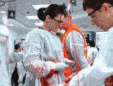 a woman in a bloody gown is standing next to a man in an orange vest with the number 4 on the wall behind them