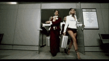 a group of women carrying suitcases are walking through an airport doorway