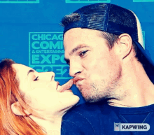 a man and a woman are kissing in front of a sign that says chicago comic & entertainment expo