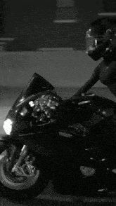 a woman wearing a helmet sits on a motorcycle that says ducati on it