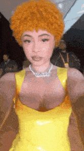 a woman in a yellow dress is taking a selfie .