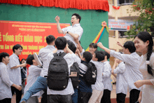 a group of students are gathered in front of a sign that says " tong ket xam hoc "