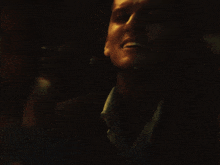 a close up of a man 's face with a dark background