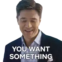 a man in a suit and plaid shirt is smiling and says you want something