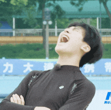 a man is laughing with his mouth open in front of a sign that says nex